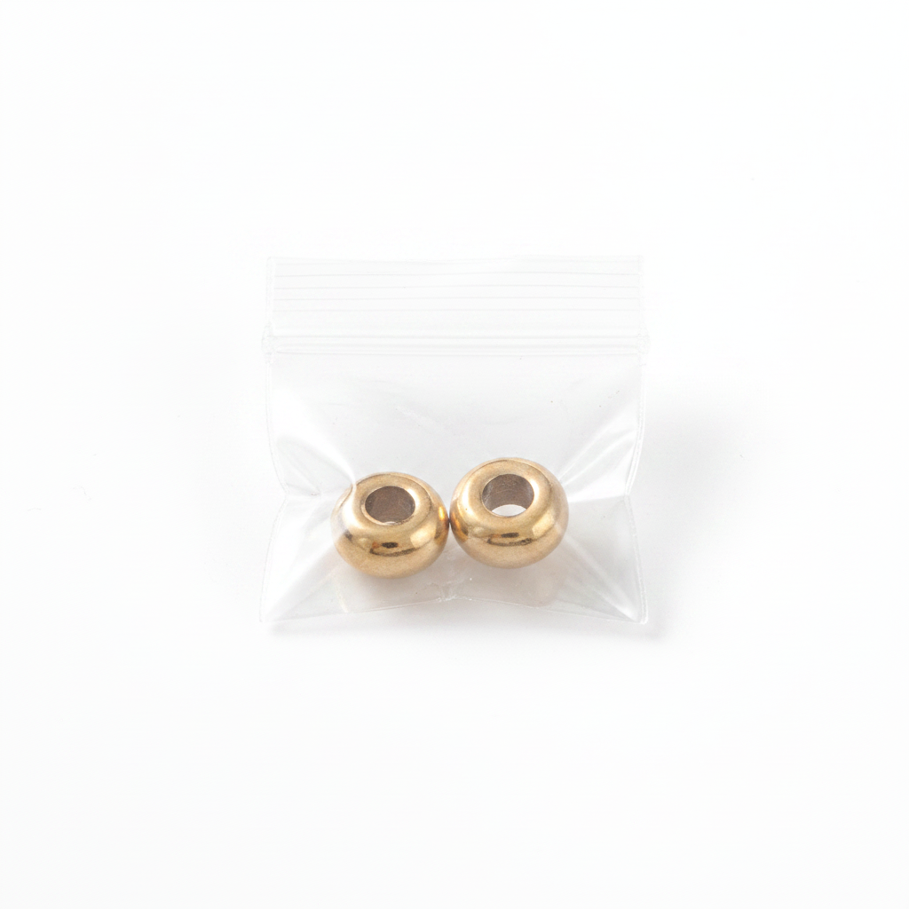 Two gold beads on a white background