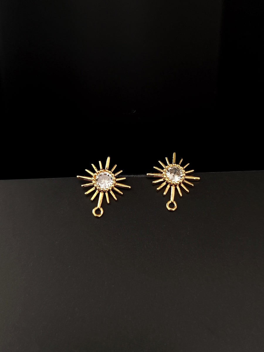 Gold sun shaped earrings with a central clear cubic zirconia stone