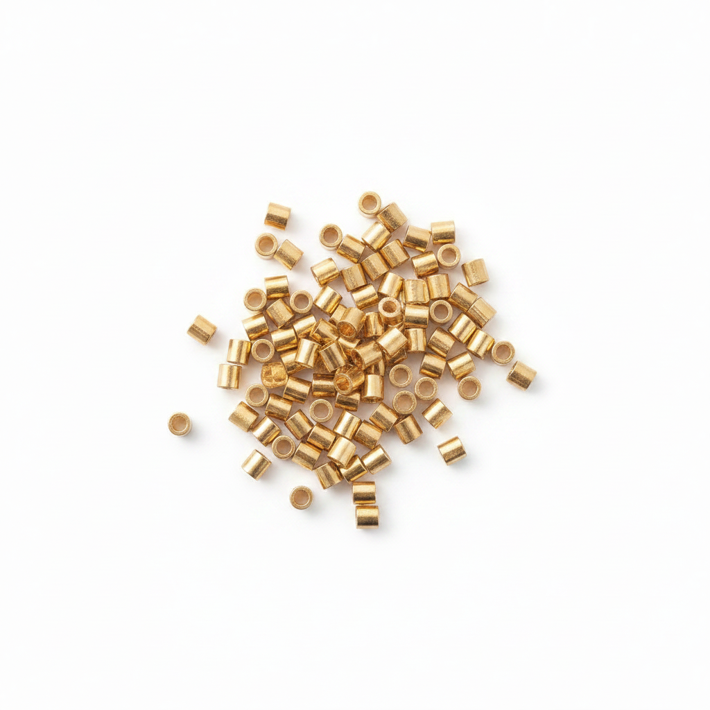 Gold cylindrical beads scattered on a white background