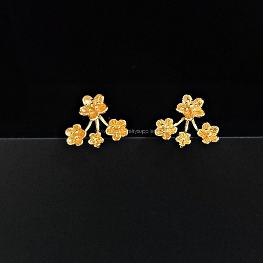 Gold floral earrings on a black background