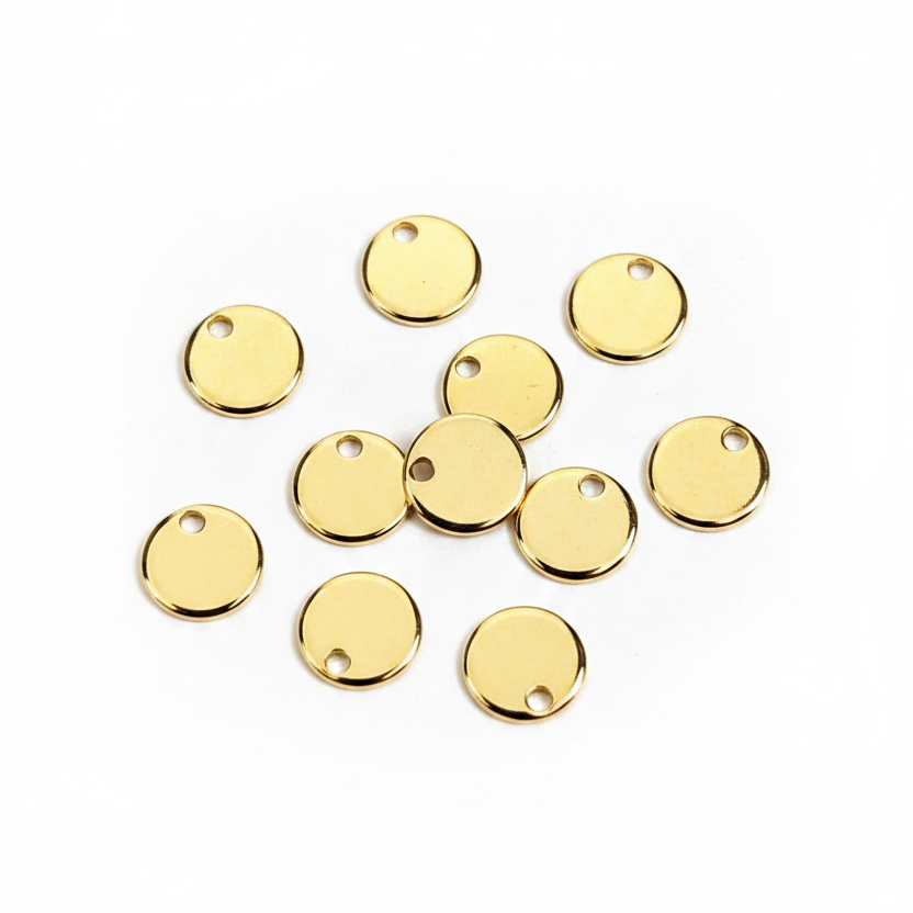 A group of small round gold metal charms with pre-drilled holes, arranged on a plain white background.