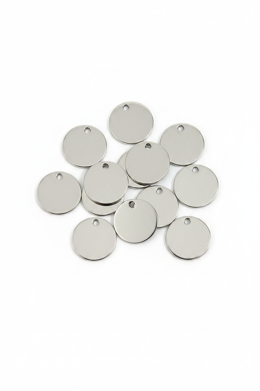 A pile of blank, round silver metal ID tags with small holes at the top, arranged on a clean white background.