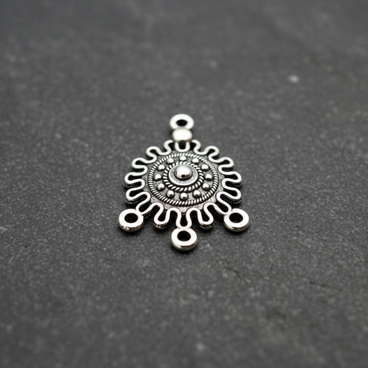 Silver decorative pendant on a black background