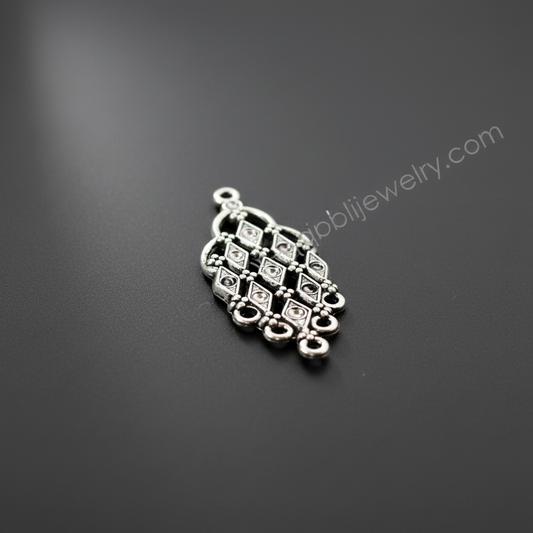Decorative silver pendant on a dark gray background