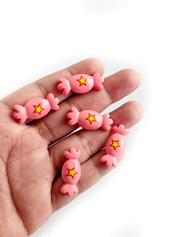 Hand holding pink dental model with yellow stars on a white background