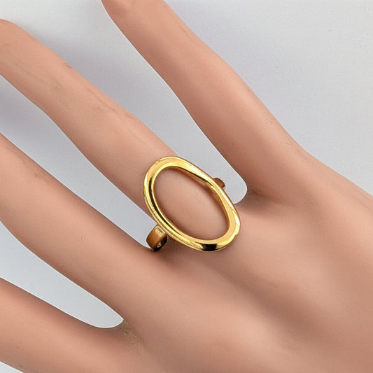 Gold ring on a mannequin hand against a white background
