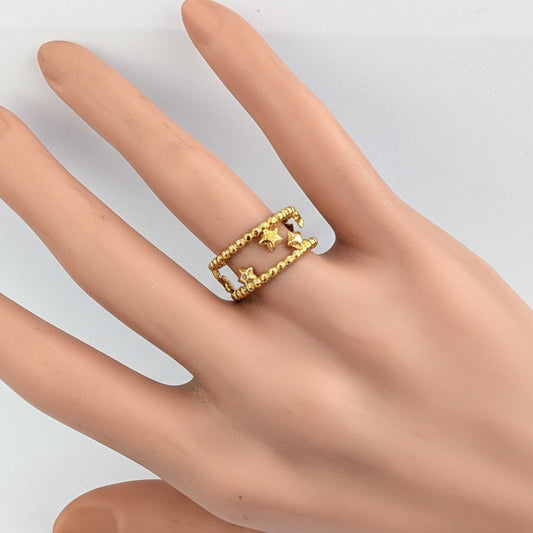 Gold ring on a mannequin hand against a white background