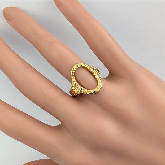 oval Gold ring on a mannequin hand against a white background