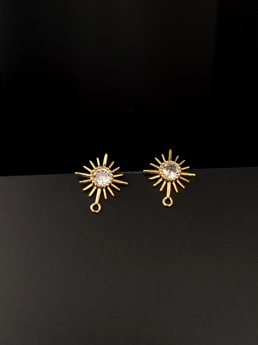 Gold sun shaped earrings with a central clear cubic zirconia stone 