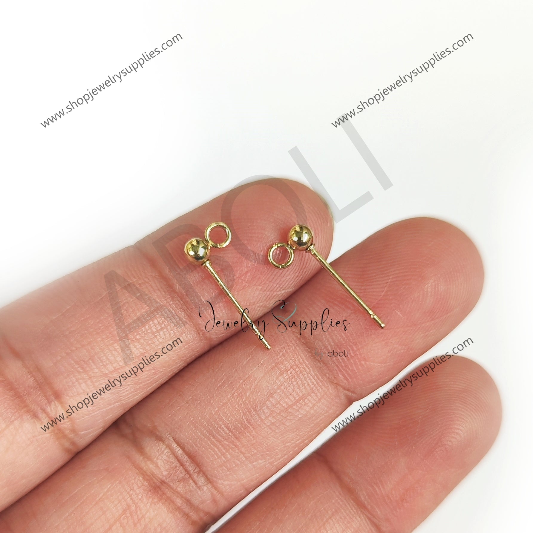 Gold earrings held between fingers on a white background with 'Alley Jewelry Supplies' branding.