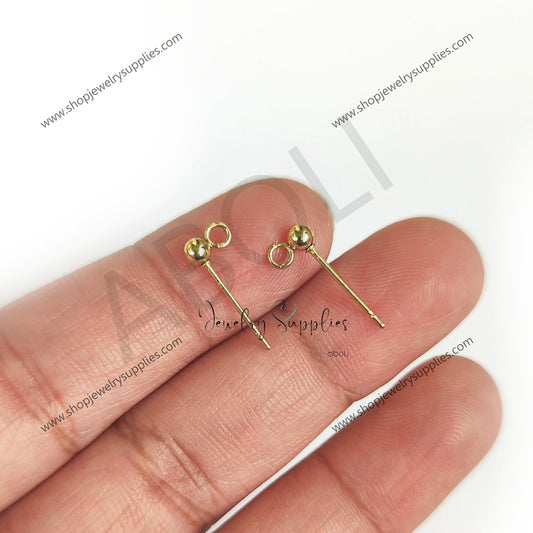 Gold earrings held between fingers on a white background with 'Alley Jewelry Supplies' branding.
