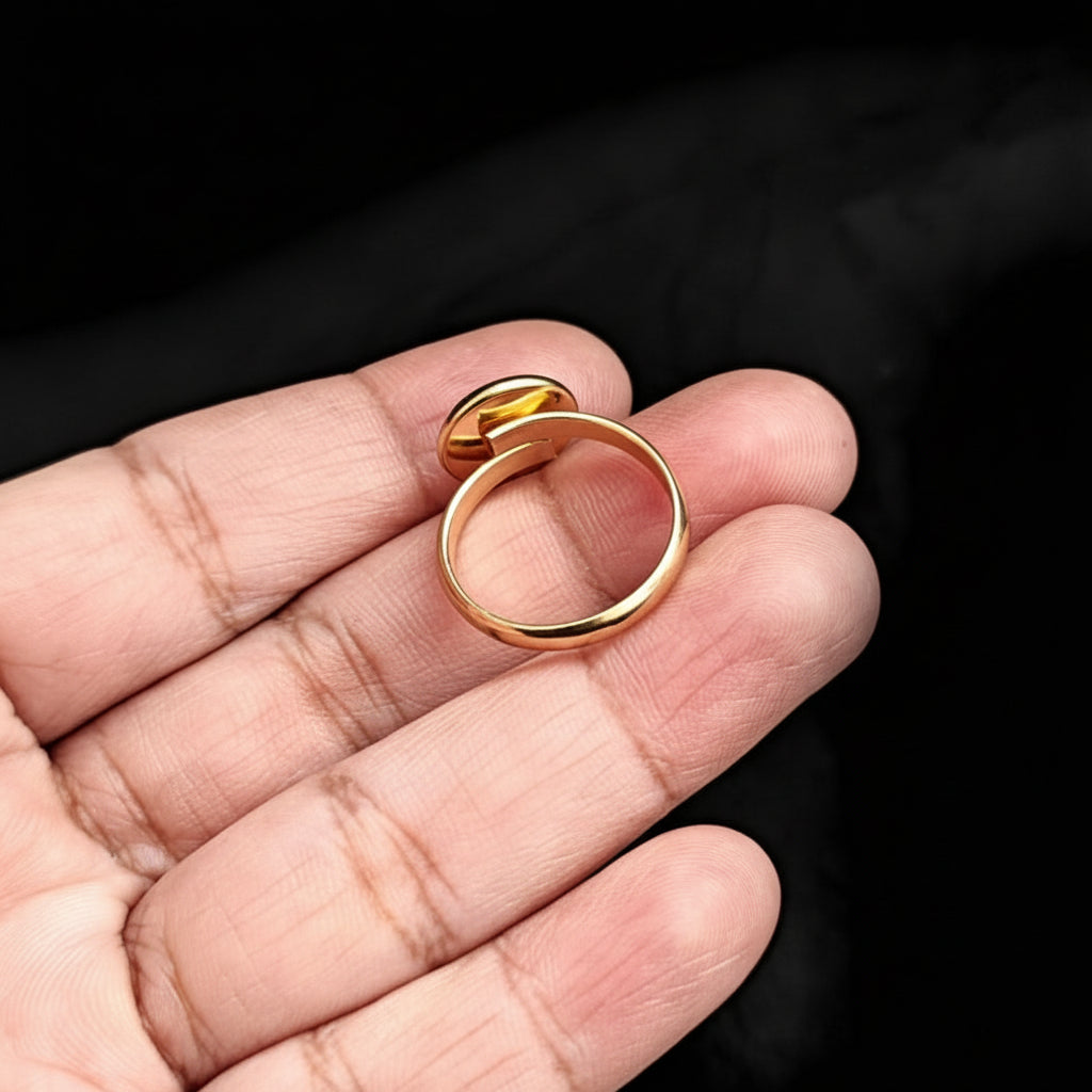 Gold ring on a person's hand against a black background