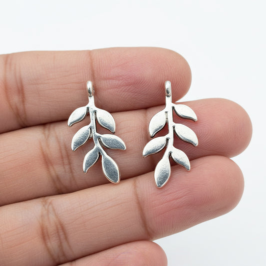Two silver leaf-shaped silver charms